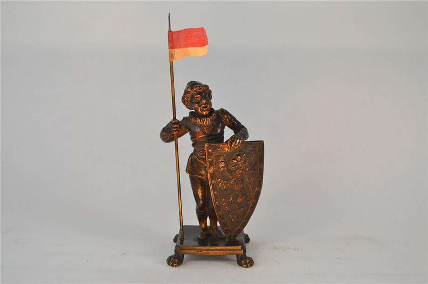 Antique bronze figure of a medieval man holding a flag