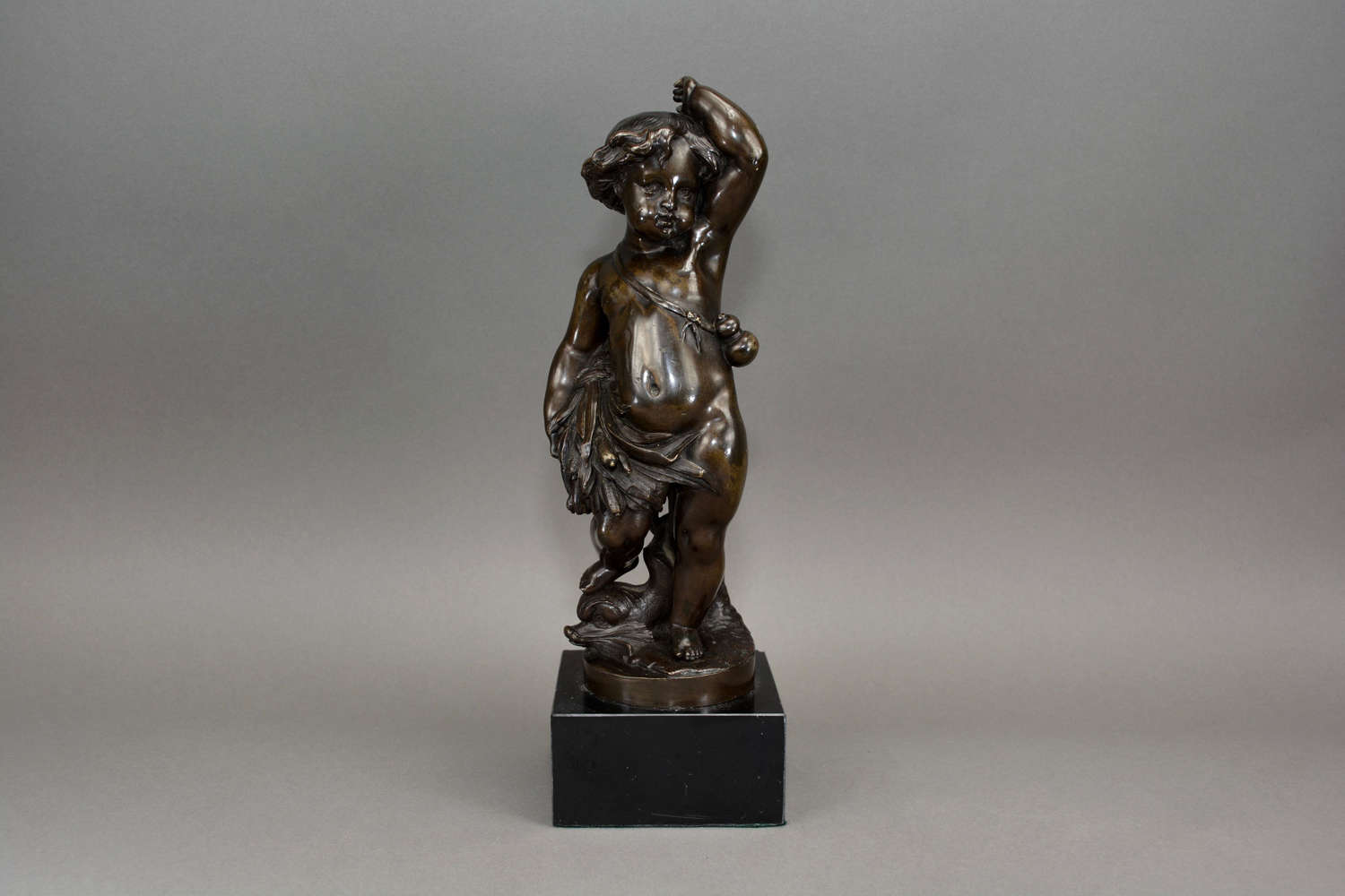 Antique bronze figure of a cherub holding a wheat sheaf