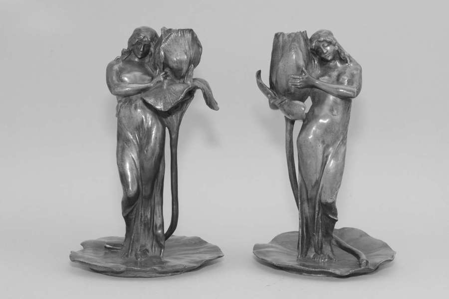 Alexandre Clerget, French, 1865-1931, two pewter figural candlesticks